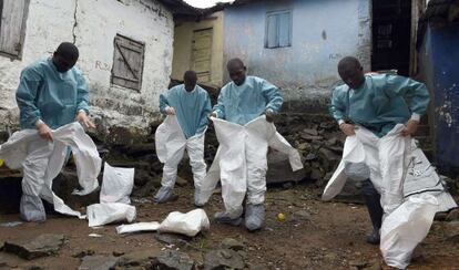 Miembros de la Cruz Roja se visten con los trajes de protección antes de recoger un cadáver en Monrovia (Liberia) en septiembre pasado.