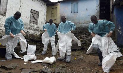 Miembros de la Cruz Roja se visten con los trajes de protecci&oacute;n antes de recoger un cad&aacute;ver en Monrovia (Liberia) en septiembre pasado.