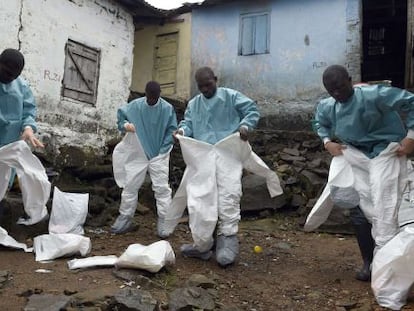 Miembros de la Cruz Roja se visten con los trajes de protecci&oacute;n antes de recoger un cad&aacute;ver en Monrovia (Liberia) en septiembre pasado.