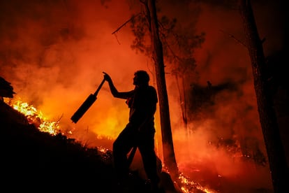 Un hombre parte de un grupo de bomberos y vecinos combate un incendio forestal en Intiyaco, provincia de Córdoba (Argentina), el 23 de septiembre de 2024.