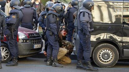 A bloodied protestor is detained by police in Valencia on Monday.
