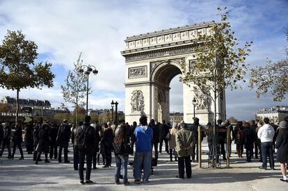 Una multitud guarda el minuto de silencio en el Arco del Triunfo en París.
