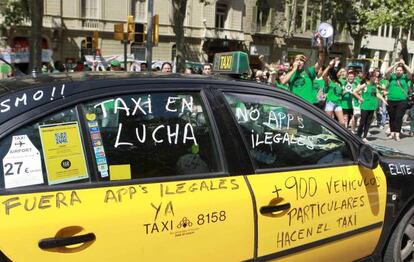 Un taxi de Barcelona pintado con varios lemas durante una manifestaci&oacute;n.