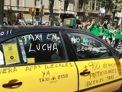 Un taxi de Barcelona pintado con varios lemas durante una manifestaci&oacute;n.