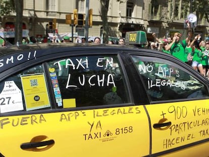 Un taxi de Barcelona pintado con varios lemas durante una manifestaci&oacute;n.