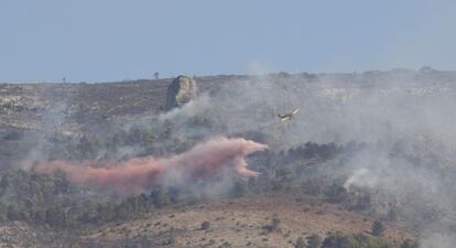 Un avión descarga agua sobre el incendio en torno a la Sierra Mariola.