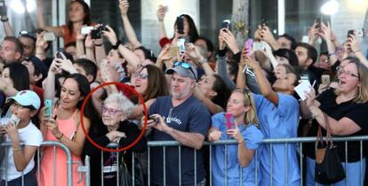 Mientras todos intentan fotografiar a los actores de la película "Black Mass", la anciana solo observa.
