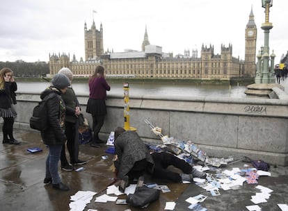 Una mujer herida yace en el suelo mientras es asistida en el puente de Westminster en Londres.