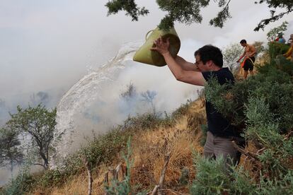 Un vecino de Añón de Moncayo echaba agua sobre las llamas el sábado. 