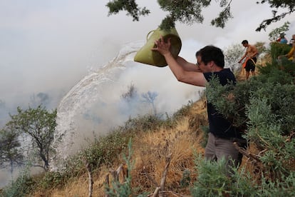 Un vecino de Añón de Moncayo echaba agua sobre las llamas el sábado. 