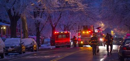 Bomberos junto à casa que se incendiou em Brooklyn.