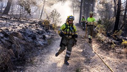 Miembros de las brigadas forestales de bomberos refrescan los alrededores de Montán (Castellón) este miércoles.
