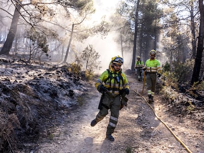 Miembros de las brigadas forestales de bomberos refrescan los alrededores de Montán (Castellón) este miércoles.