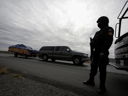 Un policía estatal de Nuevo León custodia la carretera ante la llegada de visitantes.