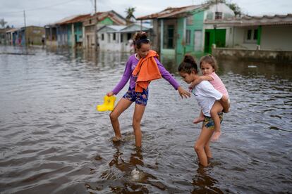 Niñas caminan por una calle inundada en Batabano, Cuba.