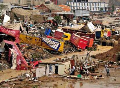 El personal de los servicios de emergencias trabajan junto a camiones y coches volcados por las fuertes lluvias en Estambul.