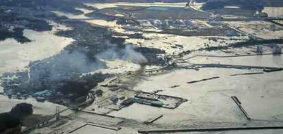 El humo se levanta en un área inundada por el tsunami en la prefectura de Fukushima, al noreste de Japón,