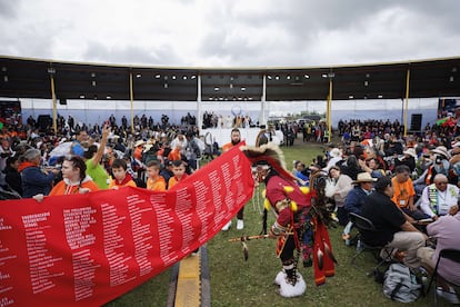 Un telón rojo con los nombres de los niños que murieron en el sistema de internados canadiense recorre la multitud durante el Pow Wow, la reunión a la que se integró el Papa.