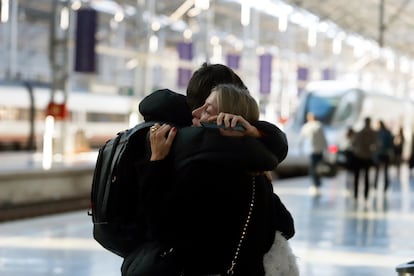 Dos personas se abrazan en la Estación María Zambrano de Sevilla, en la Navidad de 2022.