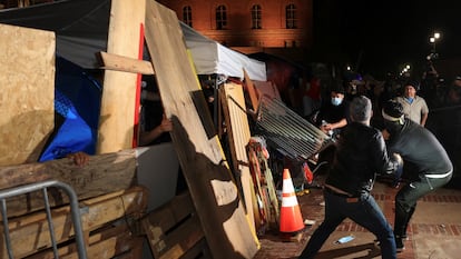 Contramanifestantes derriban una barricada en el campamento propalestino de la Universidad de Los Ángeles, en California, esta madrugada.