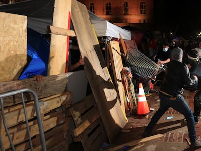 Contramanifestantes derriban una barricada en el campamento propalestino de la Universidad de Los Ángeles, en California, esta madrugada.