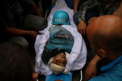 Friends and relatives mourn the bodies of Palestinian journalists Muhammad Sobh and Saeed Al-Taweel, who were killed during their work by Israeli air strikes on October 10, 2023 in Gaza City, Gaza. 