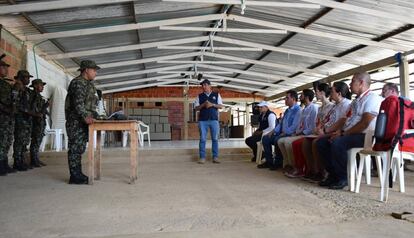 Un miembro del Estado Mayor Central, de las antiguas FARC-EP, habla con personas del Comité Internacional de la Cruz Roja, el 28 de diciembre en Valle del Cauca (Colombia).