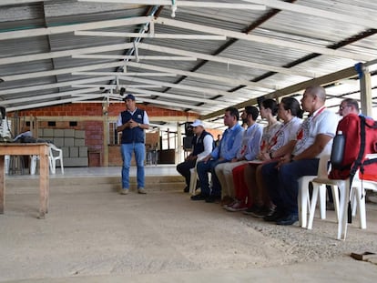 Un miembro del Estado Mayor Central, de las antiguas FARC-EP, habla con personas del Comité Internacional de la Cruz Roja, el 28 de diciembre en Valle del Cauca (Colombia).