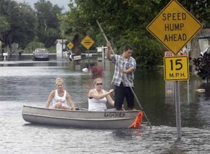 Vecinos de Cocoa, en Florida, intentan cruzar una calle inundada por las fuertes lluvias.