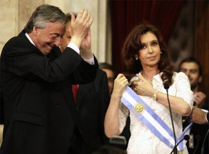 El ex presidente Kirchner aplaude a su esposa, Cristina Fernández, tras traspasarle el poder en diciembre.