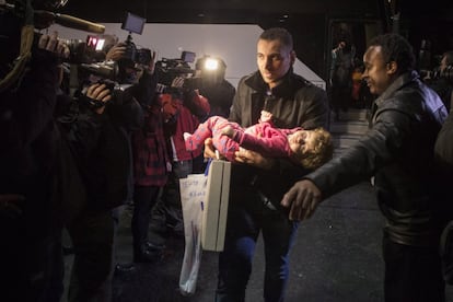 Kevork Jamkossian carries his daughter, Madeleine Jamkossian into a hotel after arriving on the first government-arranged flight into Toronto's Pearson International Airport alongside other Syrian Refugees, on Friday, Dec. 11, 2015, in Toronto. (Chris Young/The Canadian Press via AP) MANDATORY CREDIT