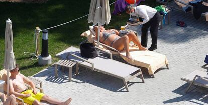 Un camarero atiende a una turista en la piscina de un hotel en Palma de Mallorca.