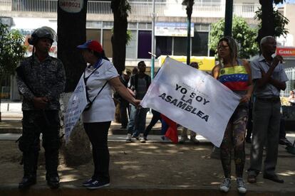 Una opositora conversa con un agente de las fuerzas de seguridad durante las primeras concentraciones de la tarde de este miércoles en Caracas.