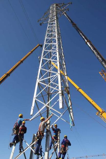 Seis especialistas tratan de encajar la cúpula de una torre.