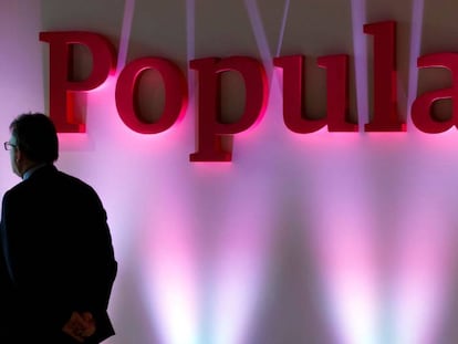 Un hombre pasa ante un cartel del Banco Popular en la presentaci&oacute;n de resultados