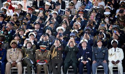 Oficiales de alto rango de varios paises usan sus teléfonos para grabar y tomar fotografías durante el tradiconal desfile militar celebrado con motivo del día de la fiesta nacional francesa en París (Francia).