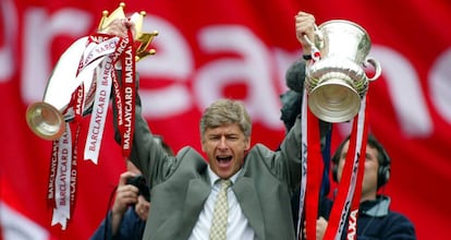 FILE PHOTO: Soccer Football - Arsenal FA Cup and League Championship Trophy Parade - Britain - May 12, 2002 Arsenal Manager Arsene Wenger celebrates by holding aloft the FA Cup and FA Barclaycard Championship trophy Action Images via Reuters/Alex Morton/File Photo