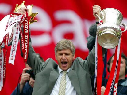 FILE PHOTO: Soccer Football - Arsenal FA Cup and League Championship Trophy Parade - Britain - May 12, 2002 Arsenal Manager Arsene Wenger celebrates by holding aloft the FA Cup and FA Barclaycard Championship trophy Action Images via Reuters/Alex Morton/File Photo