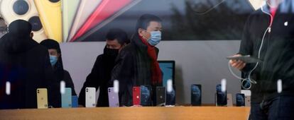 Personas con máscaras protectoras en una tienda de Apple en Shanghai (China).