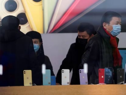 Personas con máscaras protectoras en una tienda de Apple en Shanghai (China).
