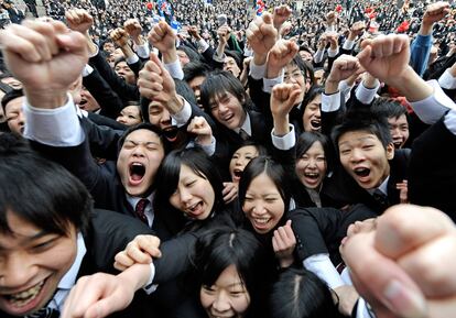 Los estudiantes universitarios japoneses elevan sus puños y gritan durante la ceremonia anual de la búsqueda de empleo en Tokio.