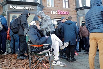 Un hombre sentado en una silla espera junto a una multitud para comprar el nuevo iPhone X en una tienda Apple en Moscú (Rusia).