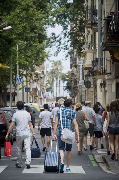 Varios turistas caminan por una calle de la ciudad de Barcelona.