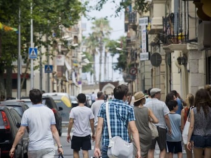 Varios turistas caminan por una calle de la ciudad de Barcelona.