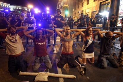 Un grupo de manifestantes se arrodilla ante la policía.