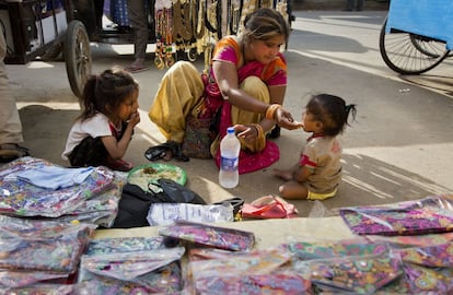 Una vendedora ambulante alimenta a sus hijos en Gauhati (India), el 7 de marzo.