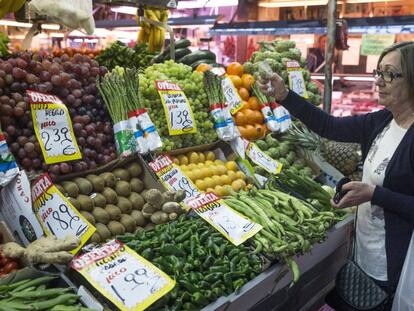 Una mujer hace su compra en una fruter&iacute;a del mercado Maravilla en Madrid