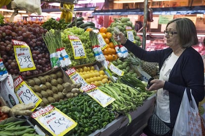 Una mujer hace su compra en una fruter&iacute;a del mercado Maravilla en Madrid