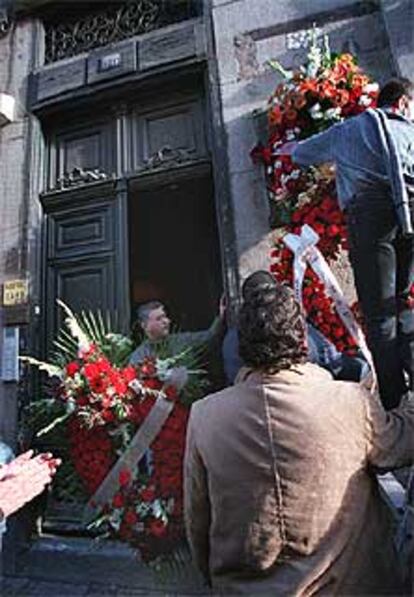 Participantes en el homenaje colocan una corona de flores en la fachada de Atocha, 55.