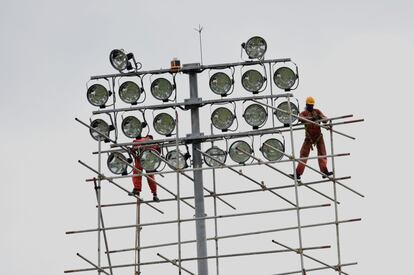 Trabajadores hacen las últimas comprobaciones en el sistema de iluminación del Estadio Rangiri, en Dambulla (Sri Lanka).
